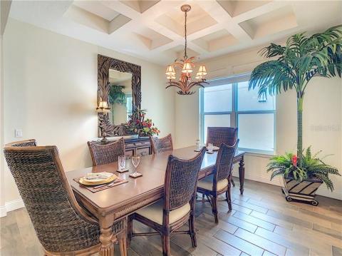 Formal dining room area with coffered ceiling and elegant chandelier