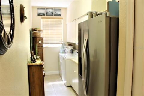 Laundry room with utility sink and second refrigerator