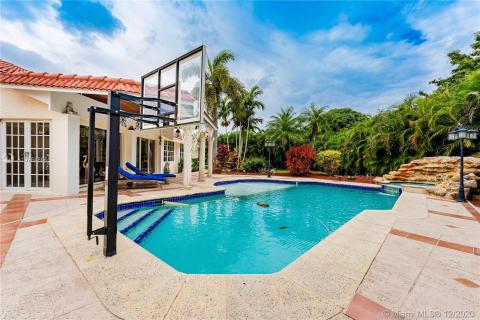 Pool with basketball hoop and cascading waterfall, beach entry