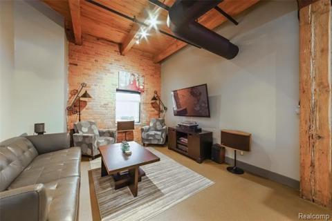 Wide open living space with exposed beams and brick walls.