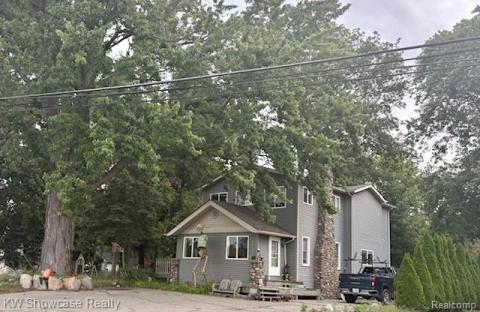 View of front of house featuring view of wooded area