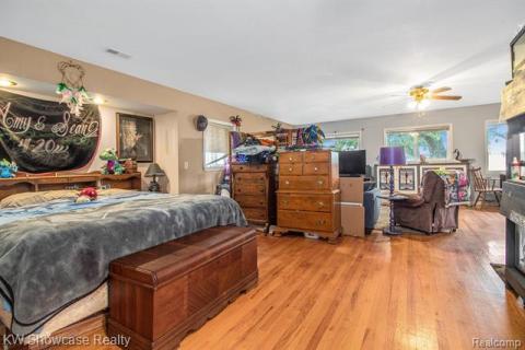 Bedroom with multiple windows and light wood finished floors