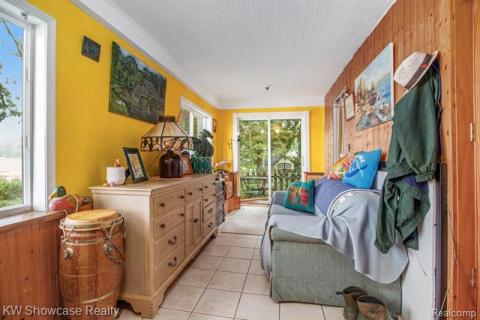 Living area with wooden walls and light tile patterned flooring
