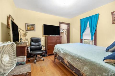 Bedroom featuring light wood finished floors and a desk