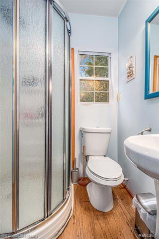 Bathroom featuring light wood-style floors and a stall shower