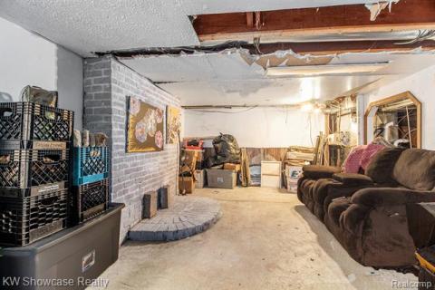 Partially finished basement featuring brick wall