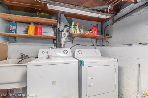 Washroom with washing machine and dryer and a sink