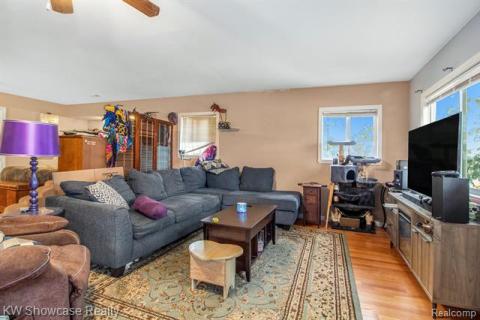 Living area featuring light wood-style floors and ceiling fan