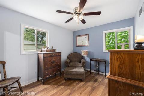 Sitting room with wood finished floors and a ceiling fan