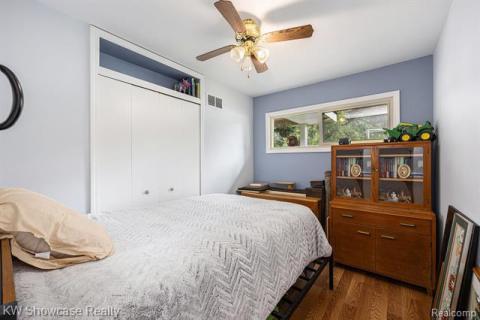 Bedroom with wood finished floors, a closet, and a ceiling fan