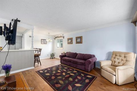 Living area with light wood-style flooring and a textured ceiling