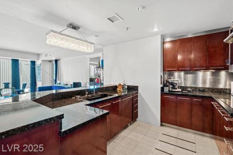 Kitchen with modern cabinets, dark stone counters, and dark brown cabinets Kitchen with modern cabinets, dark stone counters, and dark brown cabinets