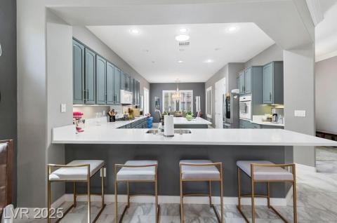 Kitchen with a chandelier, a breakfast bar area, a peninsula, a center island, and recessed lighting