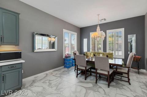 Dining area with a chandelier and light marble finish flooring