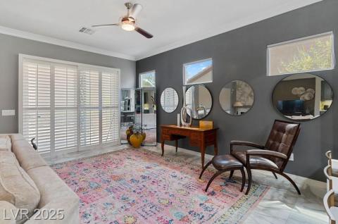 Office space with ornamental molding, marble look tile flooring, and a ceiling fan