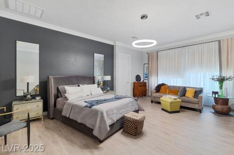 Bedroom with crown molding and light wood finished floors