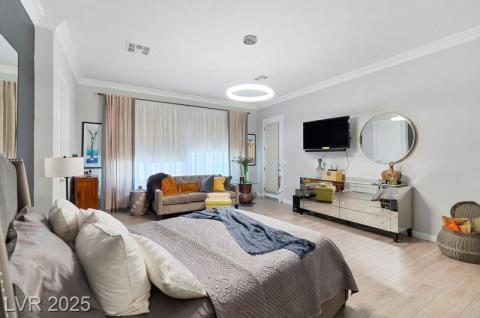 Bedroom with ornamental molding and wood finished floors