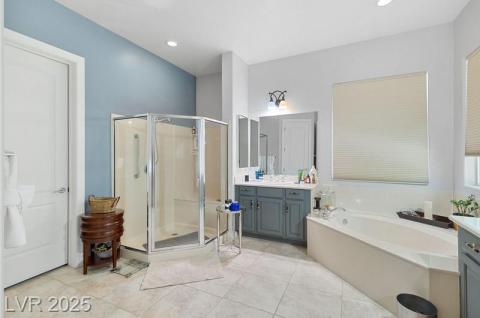 Full bathroom featuring vanity, a shower stall, a garden tub, light tile patterned floors, and recessed lighting