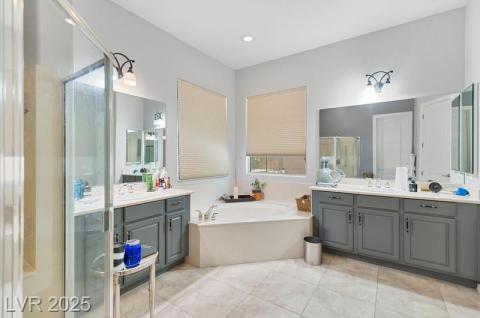 Bathroom with a stall shower, two vanities, a garden tub, light tile patterned flooring, and recessed lighting