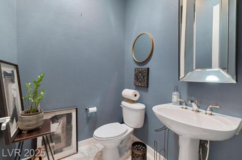 Half bathroom with a textured wall and toilet