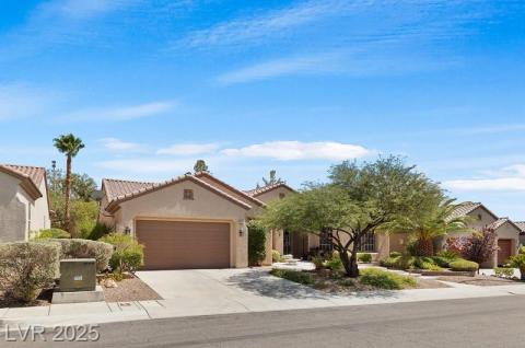 Mediterranean / spanish house with concrete driveway, an attached garage, stucco siding, and a tile roof