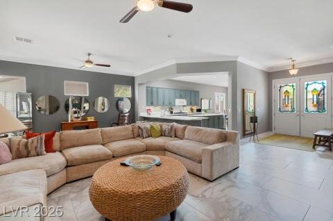 Living room with light marble finish floors, crown molding, and a ceiling fan