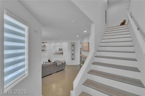 Stairs with recessed lighting and concrete floors