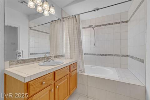 Jack & Jill Bathroom featuring vanity, tiled shower / bath combo, and light tile patterned floors