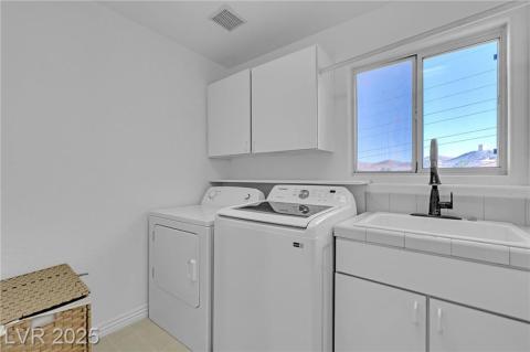 Laundry room w/beautiful mountain views featuring cabinet space and washer and clothes dryer