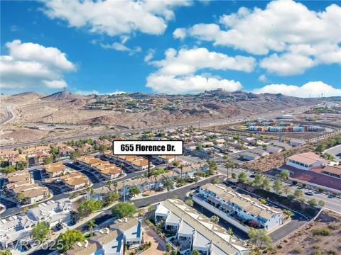Aerial view of property's location with nearby suburban area and a mountain backdrop