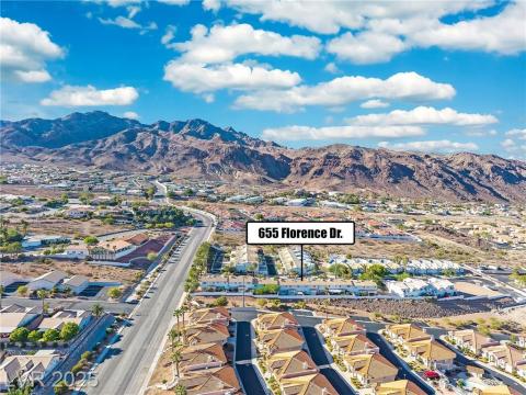Aerial view of property's location with nearby suburban area and a mountain backdrop