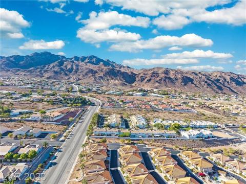 Aerial view of property's location featuring nearby suburban area and mountains