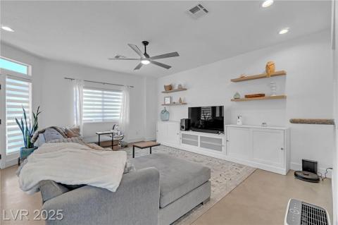 Living area featuring recessed lighting and a ceiling fan and floating shelves