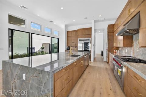 Kitchen with Wolf appliances, upgraded cabinets, luxury wood plank flooring, quartzite countertops & backsplash, and recessed lighting Kitchen with Wolf appliances, upgraded cabinets, luxury wood plank flooring, quartzite countertops & backsplash, and recessed lighting