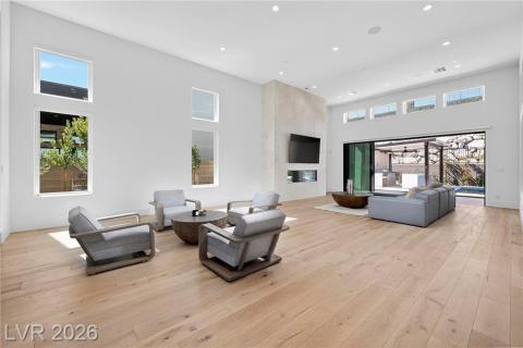 Family area featuring a high ceiling, luxury wood plank flooring, and recessed lighting Family area featuring a high ceiling, luxury wood plank flooring, and recessed lighting
