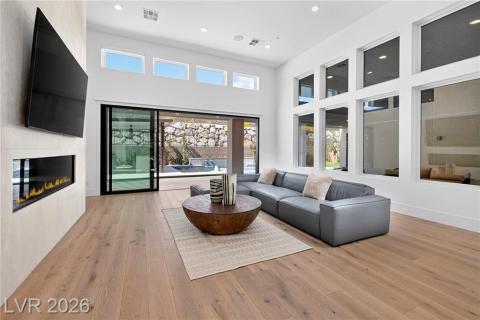 Family room with a high ceiling, a 6ft linear fireplace w/remote, recessed lighting, luxury wood plank flooring & stacked sliding doors to resort style backyard Family room with a high ceiling, a 6ft linear fireplace w/remote, recessed lighting, luxury wood plank flooring & stacked sliding doors to resort style backyard