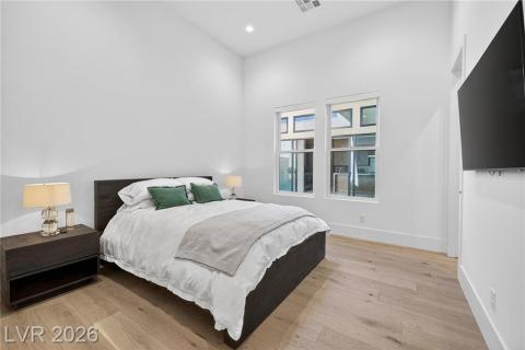 Bedroom featuring luxury wood plank flooring, remote shades with blackouts, recessed lighting, 3/4 bath & walk-in closet Bedroom featuring luxury wood plank flooring, remote shades with blackouts, recessed lighting, 3/4 bath & walk-in closet