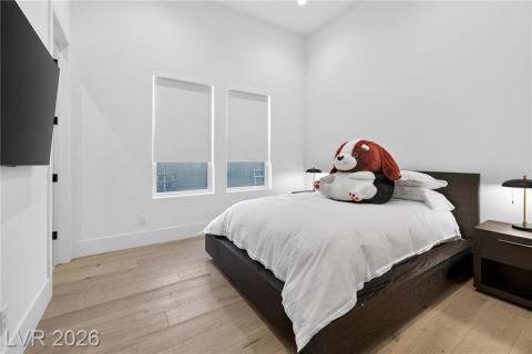 Bedroom with luxury wood plank flooring, recessed lighting, remote shades with blackouts, a full bathroom & walk-in closet Bedroom with luxury wood plank flooring, recessed lighting, remote shades with blackouts, a full bathroom & walk-in closet
