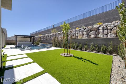 Fenced backyard with a patio, an outdoor pool, and a pergola. Bay Laurel Trees surround the perimeter and have auto-fertilization system Fenced backyard with a patio, an outdoor pool, and a pergola. Bay Laurel Trees surround the perimeter and have auto-fertilization system