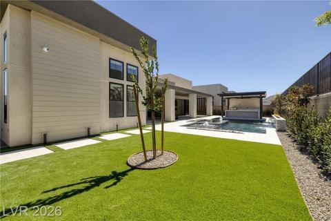 Rear view of property featuring a fenced backyard, a patio area, a hot tub, and stucco siding Rear view of property featuring a fenced backyard, a patio area, a hot tub, and stucco siding