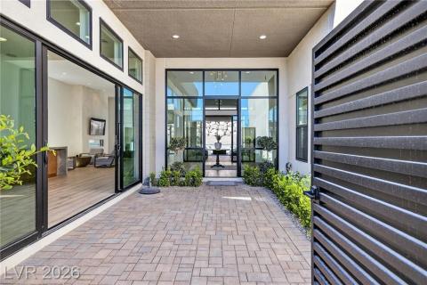Doorway to property featuring upgraded/added steps, decorative driveway, a garage, and a upgraded/added security gate Doorway to property featuring upgraded/added steps, decorative driveway, a garage, and a upgraded/added security gate