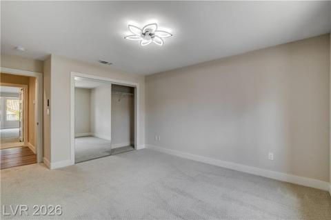 This light-filled bedroom features plush carpeting, a modern ceiling light, and ample closet space. This light-filled bedroom features plush carpeting, a modern ceiling light, and ample closet space.
