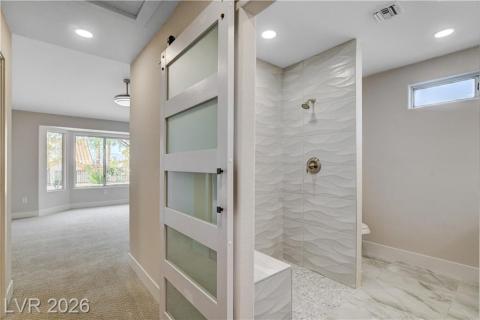 This primary bathroom and adjacent room showcase a modern shower design and bright, inviting spaces. This primary bathroom and adjacent room showcase a modern shower design and bright, inviting spaces.