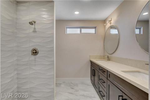 This sleek bathroom features a modern shower and double vanity with elegant fixtures. This sleek bathroom features a modern shower and double vanity with elegant fixtures.