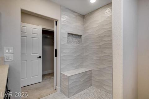 This modern bathroom features a spacious shower with textured tile and a convenient built-in bench. This modern bathroom features a spacious shower with textured tile and a convenient built-in bench.