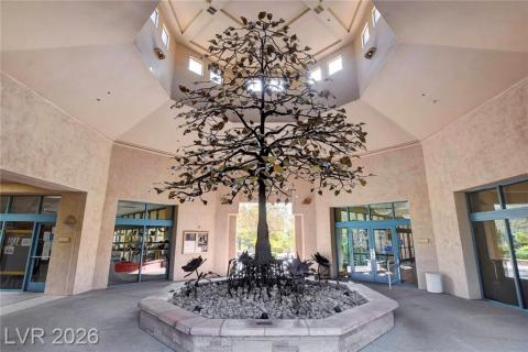 An inviting foyer showcases a striking tree sculpture, illuminated by skylights and natural light. An inviting foyer showcases a striking tree sculpture, illuminated by skylights and natural light.