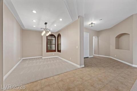Recessed lighting and a stylish chandelier illuminate this adaptable, open-concept living space.