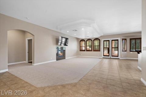 A spacious living area offers a cozy fireplace and seamless outdoor access through elegant French doors.