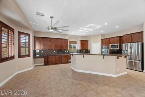 A well-appointed culinary space featuring ample dark wood cabinetry and granite surfaces.