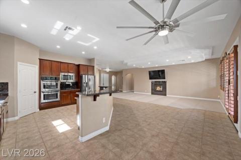 An inviting open-concept living space features a spacious kitchen island and a cozy fireplace, perfect for gatherings.